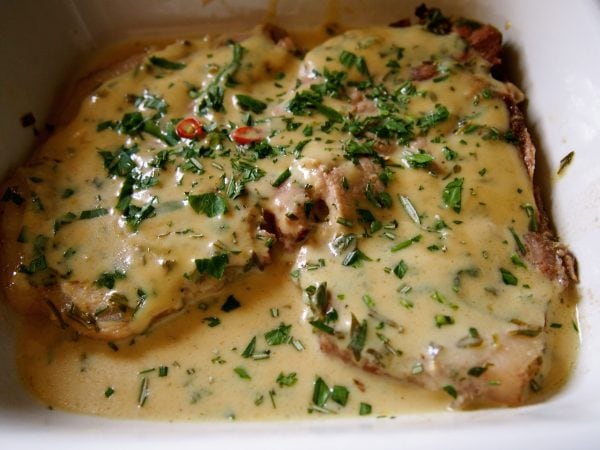 Porsaankyljykset uunissa, päällystetty juustoisella hunajaisella kastikkeella ja yrteillä.