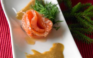 Graavilohi, hunajainen ja tuore, tarjoiltuna vihreiden yrttien kanssa.