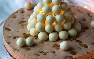 Lumilyhtykakku, jossa valkoisia marenkeja ja hunajaa, juhlapöydän herkku.