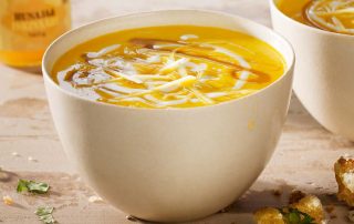 Hunajainen inkivääri porkkanakeitto lautasella, terveellinen ja maukas resepti.