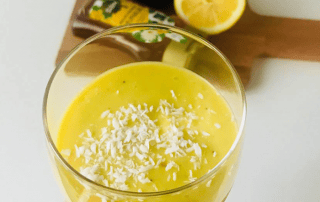 Aurinko-smoothie, jossa on sitrushedelmiä ja kookoshiutaleita, tarjoaa raikkaan ja terveellisen juom.