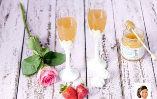 Kaksi lasillista hunajateetä ja tuoreita mansikoita, romanttinen teema.