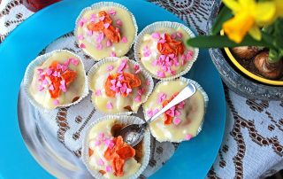 Hunajaiset porkkana-hunaja cupcaket, koristeltu vaaleanpunaisilla ja oransseilla strösseleillä.