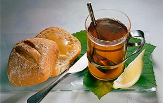 Hunajainen SAM -hunajatee ja tuore leipä sitruunalla.