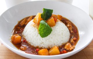 Hunajainen SAM -sivuston kuva, mausteinen kanakastike ja jasmiiniriisi lautasella.