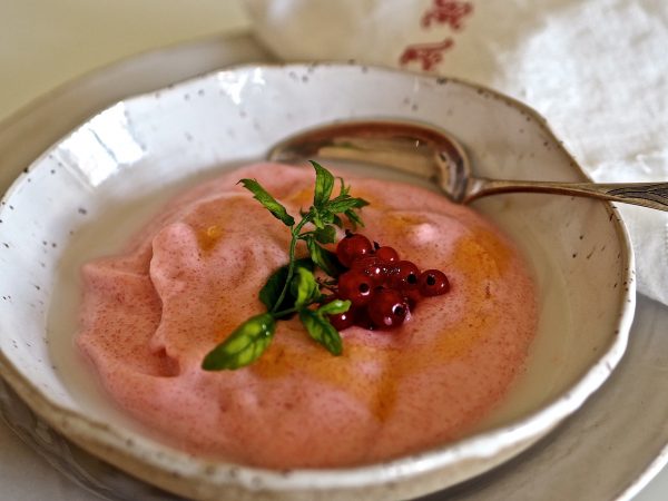 Hunajainen lappapuuro tarjoiltuna kauniissa kulhossa, koristeltuna marjoilla ja mintunlehdellä.