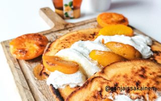 Persikkaiset pannukakut hunajalla ja kermavaahdolla, herkullinen aamiainen tai jälkiruoka.