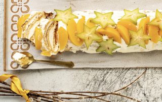 Hunajalla makeutettu persikka-kääretorttu, koristeltu hedelmäsilueteilla.